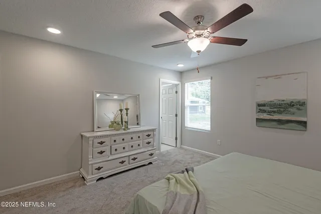 a bedroom with a bed and a ceiling fan