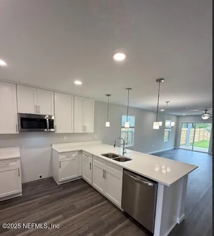 a large white kitchen with a white stove top oven and white cabinets