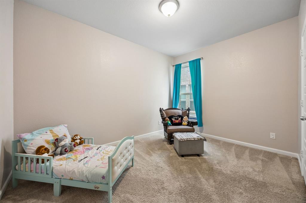 638 Hazeltine Road Red Oak, TX 75154 - Photo 7 of 29 a bedroom with a bed and a window