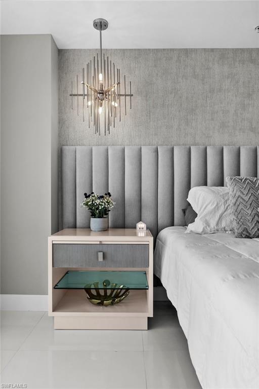 3000 Oasis Grand Boulevard, Unit 2007 Fort Myers, FL 33916 - Photo 13 of 45 a spacious bedroom with a bed and chandelier