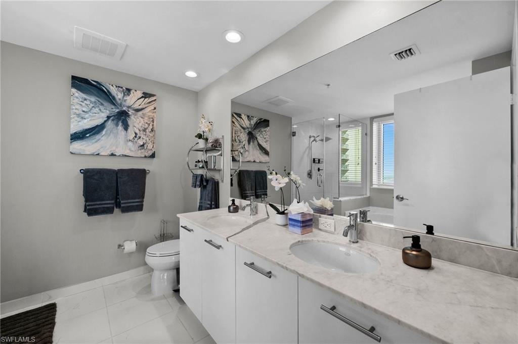 3000 Oasis Grand Boulevard, Unit 2007 Fort Myers, FL 33916 - Photo 17 of 45 a bathroom with double vanity sinks a toilet and a mirror