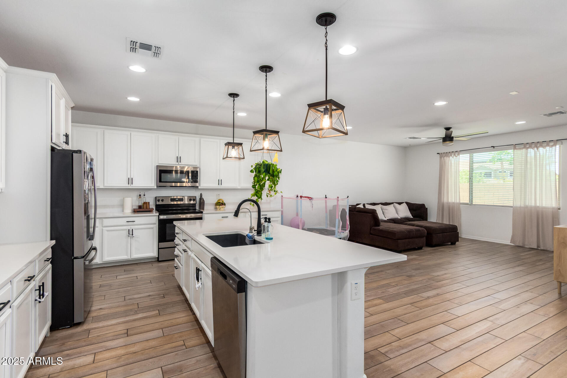24608 Seed Road Florence, AZ 85132 - Photo 15 of 45 a kitchen with counter top space a sink stainless steel appliances and wooden floor