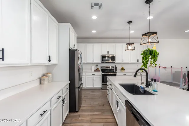 a kitchen with kitchen island a sink appliances and cabinets