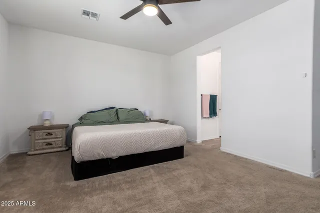 a bedroom with a bed and a ceiling fan