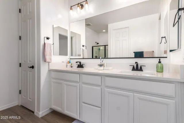 a bathroom with double sink and a mirror