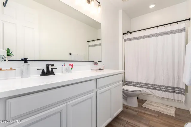 a spacious bathroom with a double vanity sink mirror and toilet
