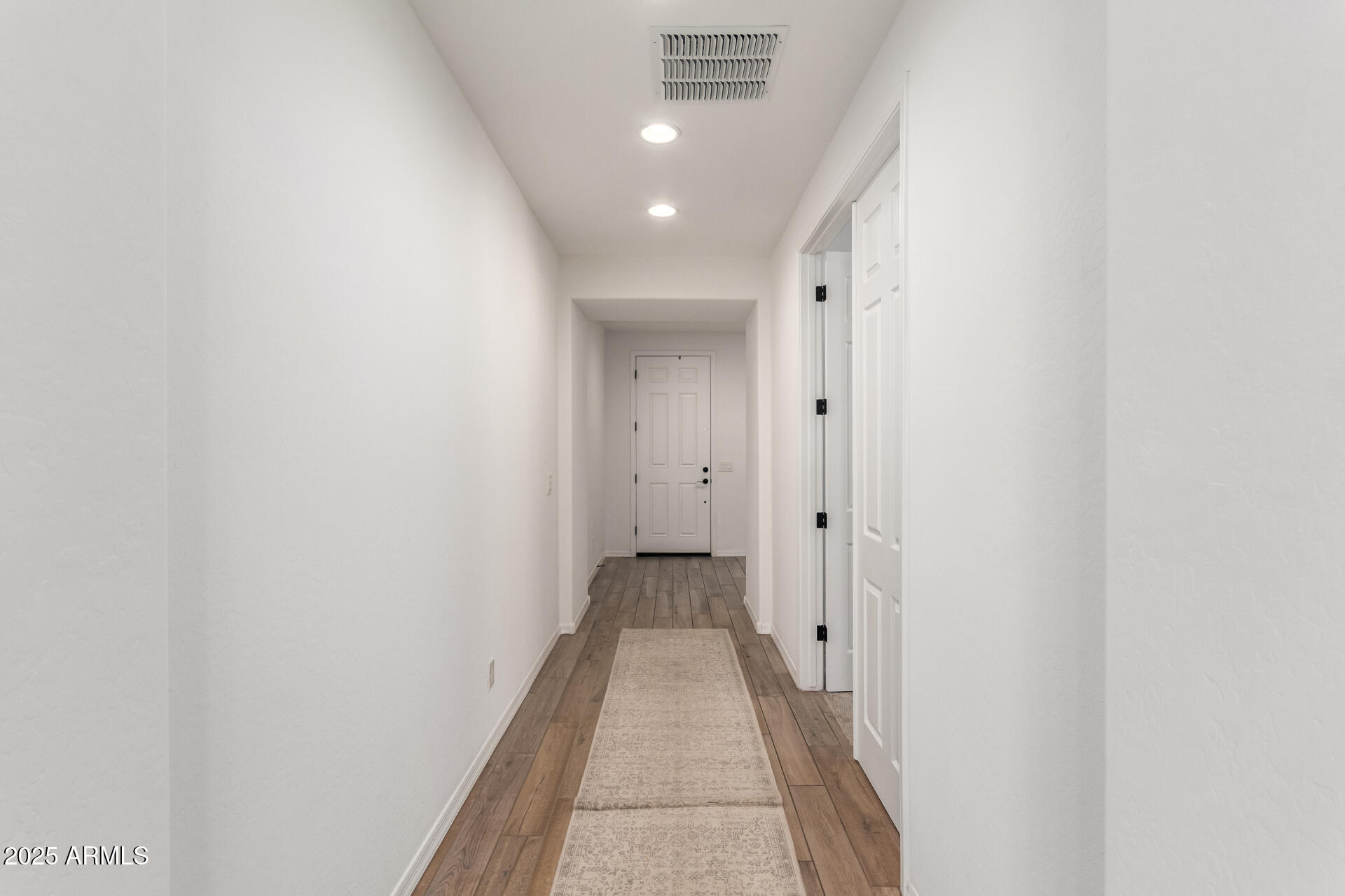 24608 Seed Road Florence, AZ 85132 - Photo 8 of 45 a view of a hallway with wooden floor and a bathroom