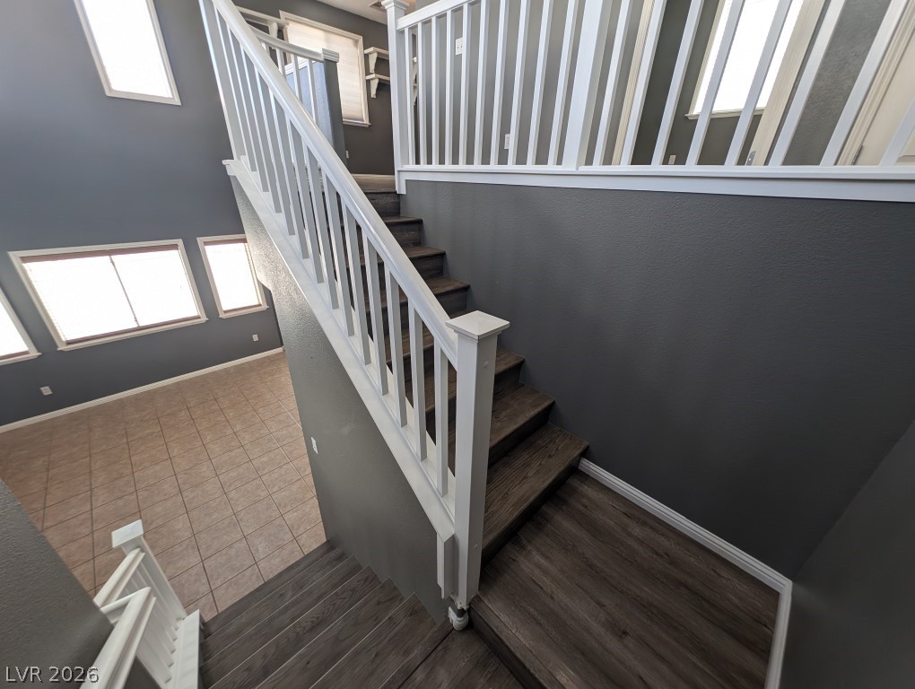 9121 Spoonbill Ridge Place Las Vegas, NV 89143 - Photo 8 of 26 Cascading steps with a classic white railing lead to sun-filled living spaces below.