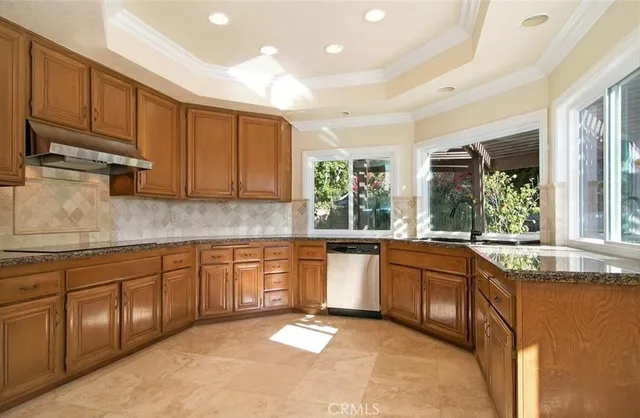 a large kitchen with granite countertop sink and cabinets