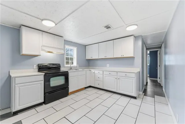 a kitchen with a stove top oven sink and cabinets