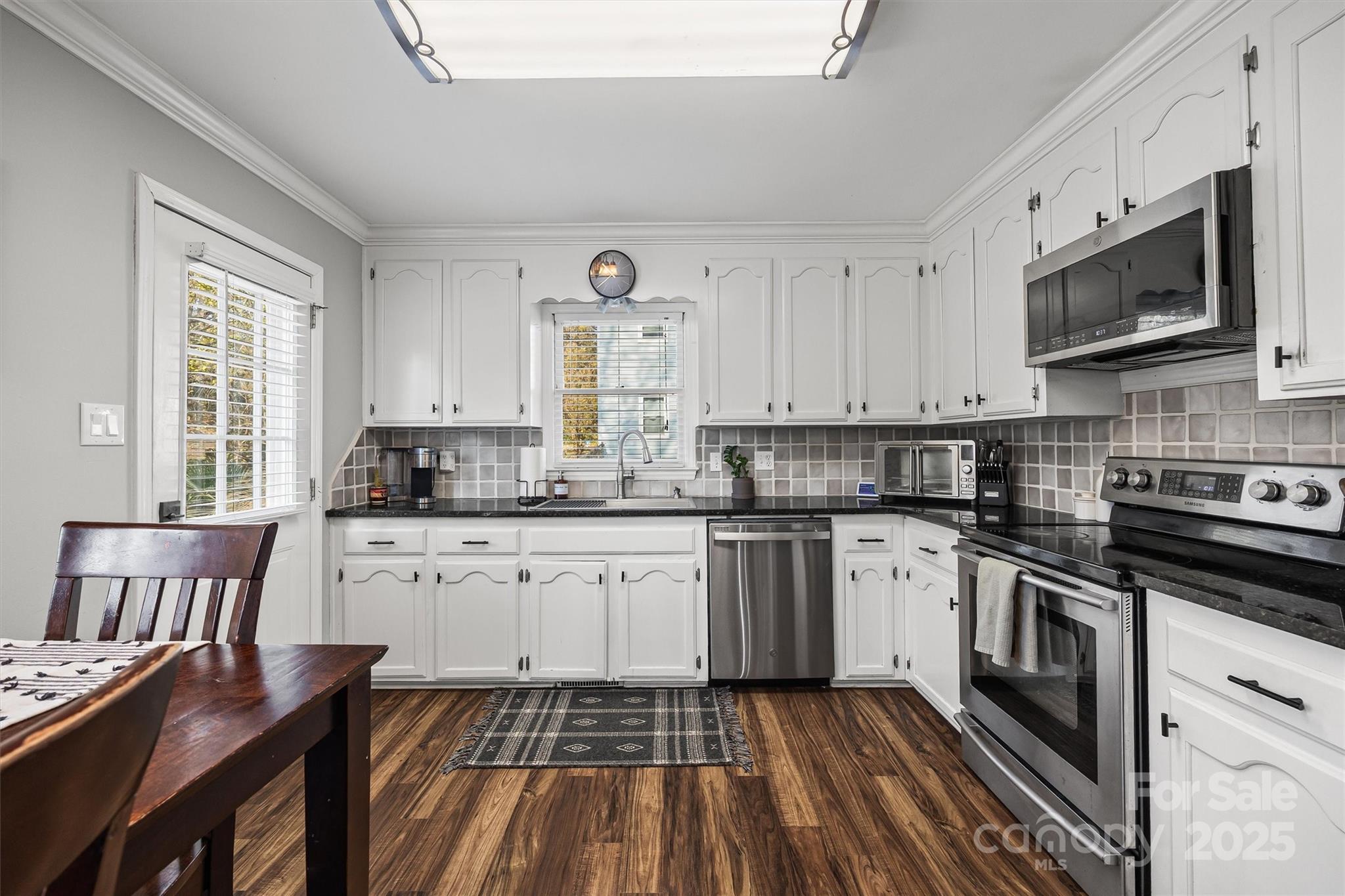 521 Rabun Circle Rock Hill, SC 29730 - Photo 9 of 28 a kitchen with stainless steel appliances granite countertop a stove top oven a sink dishwasher and white cabinets with wooden floor