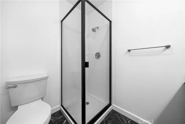 a bathroom with a toilet and a shower