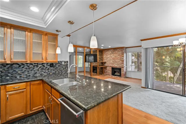 a kitchen with stainless steel appliances granite countertop a sink a stove cabinets counter space and a large window