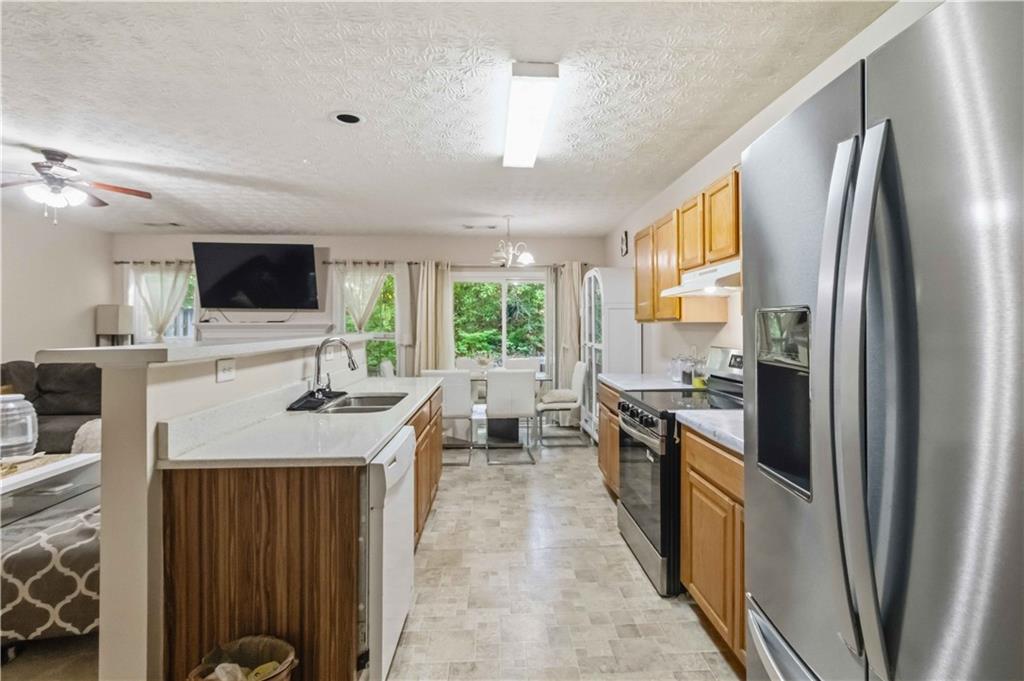 6031 Grovegate Lane Tucker, GA 30084 - Photo 11 of 26 a kitchen with stainless steel appliances granite countertop a refrigerator a stove a sink and a microwave