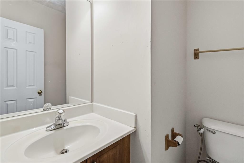 6031 Grovegate Lane Tucker, GA 30084 - Photo 14 of 26 a bathroom with a sink toilet and a mirror