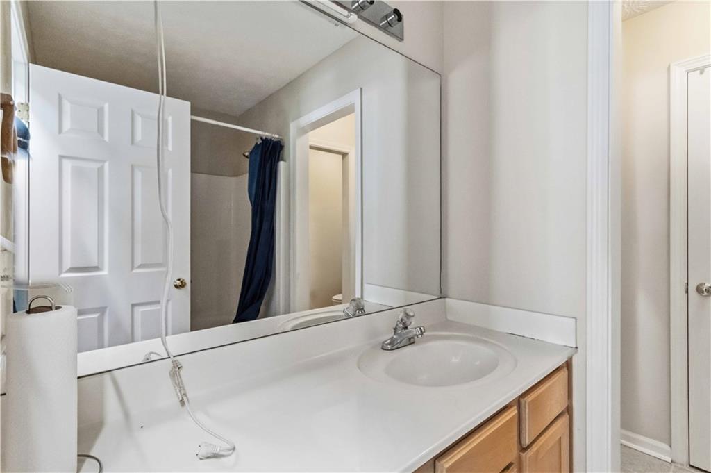6031 Grovegate Lane Tucker, GA 30084 - Photo 15 of 26 a bathroom with a granite countertop sink and a mirror