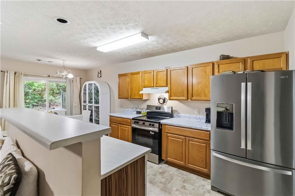 6031 Grovegate Lane Tucker, GA 30084 - Photo 10 of 26 a kitchen with refrigerator a stove a sink dishwasher and microwave with wooden floor