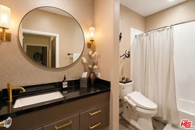 a bathroom with a sink a toilet and a mirror