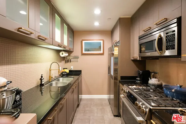 a kitchen with stainless steel appliances granite countertop a stove and a microwave