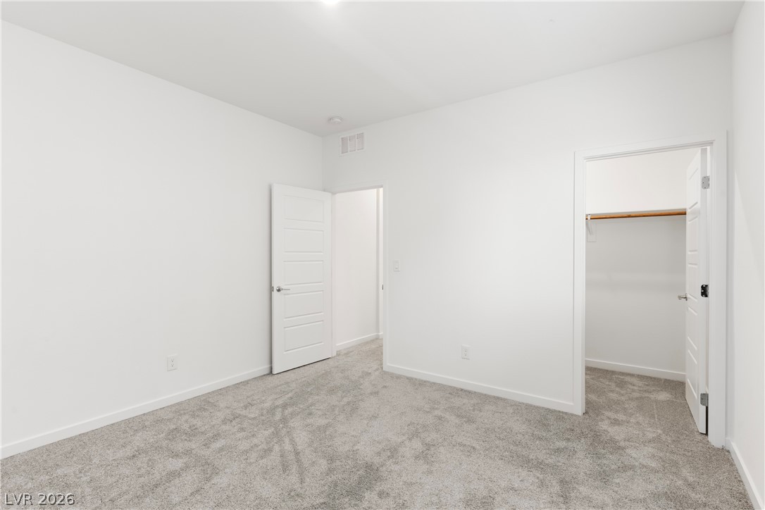 320 Isla Enclave Way Henderson, NV 89011 - Photo 31 of 49 This unfurnished bedroom showcases plush carpeting and ample space, ready for personalization.