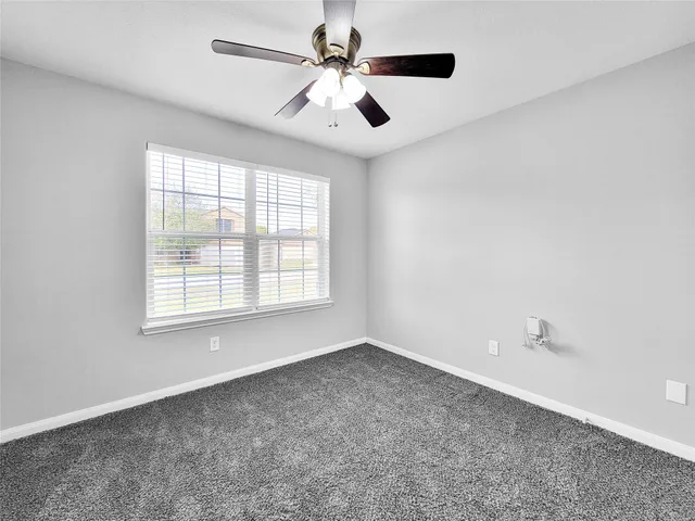 an empty room with chandelier fan