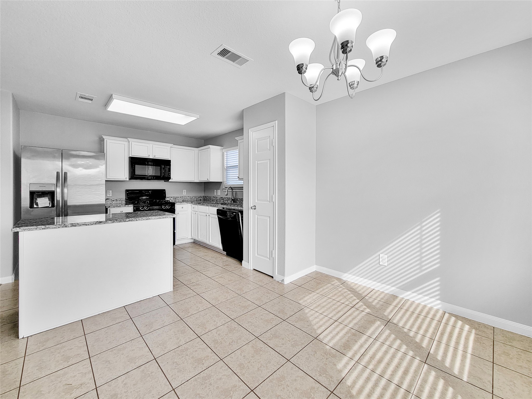 930 Paradise Road Baytown, TX 77521 - Photo 5 of 18 a kitchen with stainless steel appliances granite countertop a refrigerator a sink dishwasher a stove and white cabinets with wooden floor