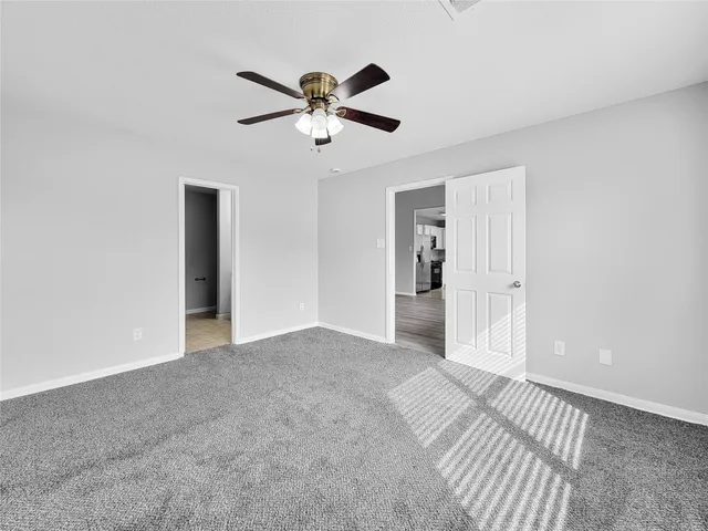 a view of a livingroom with a ceiling fan & entryway