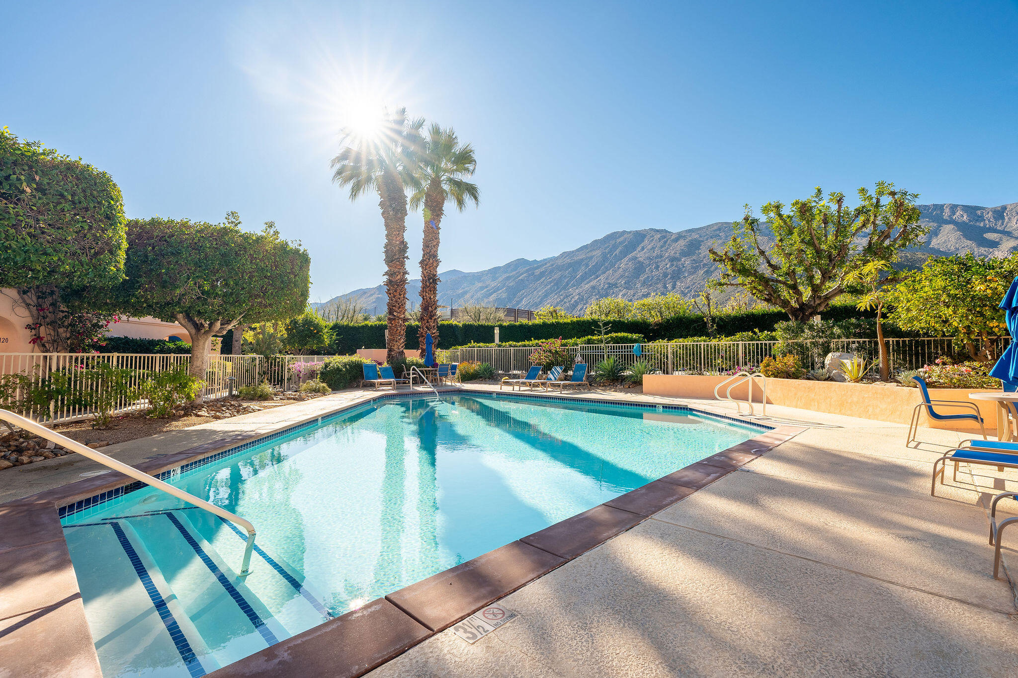 500 East Amado Road, Unit 106 Palm Springs, CA 92262 - Photo 24 of 30 a view of a swimming pool with a lawn chairs under an umbrella