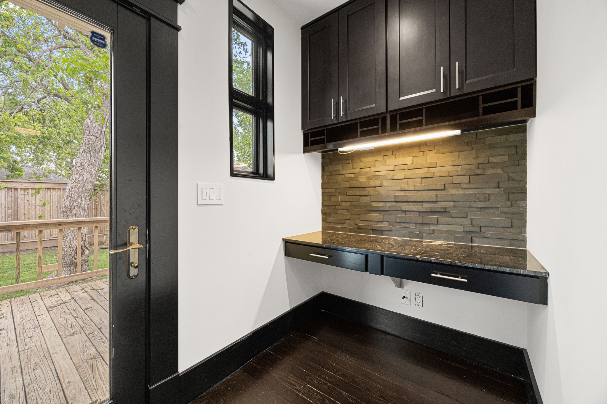 1115 Adele Street Houston, TX 77009 - Photo 8 of 19 Built-in bar or workspace with custom cabinetry, granite countertop, and stylish backsplash.