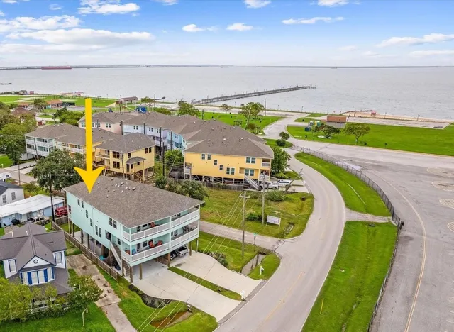 a view of a swimming pool with a lawn chairs and floor to ceiling window
