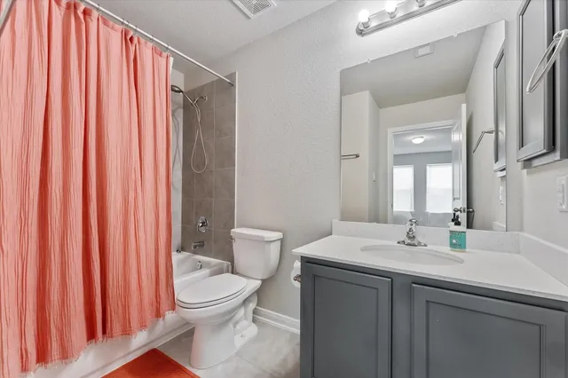 a bathroom with a sink a toilet and shower curtain