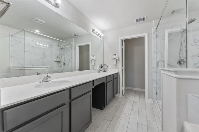 a bathroom with a double vanity sink mirror and shower