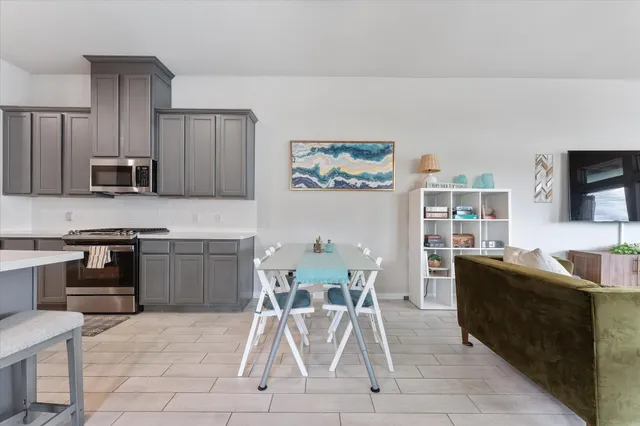 a kitchen with stainless steel appliances kitchen island granite countertop a sink and a refrigerator