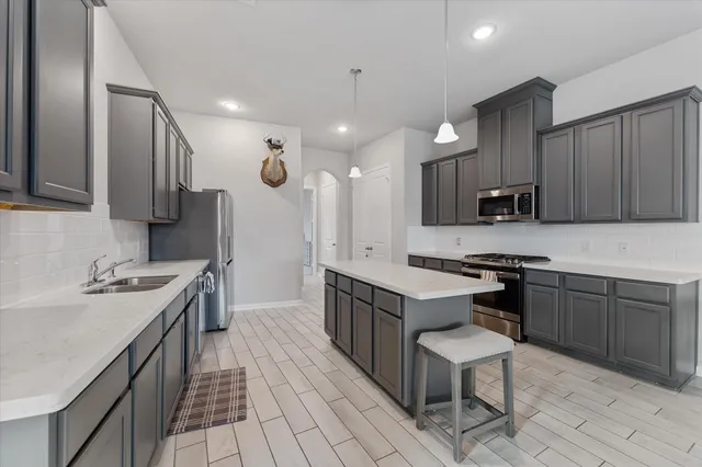 a kitchen with a sink stove and wooden cabinets