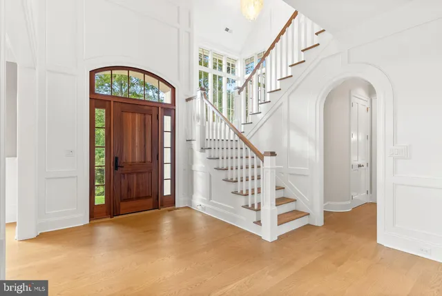 a view of a hallway with wooden floor and staircase