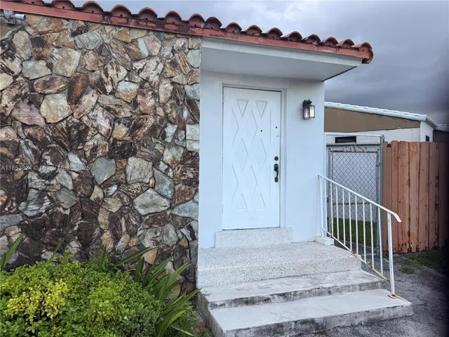 a view of a porch with a bench and potted plants