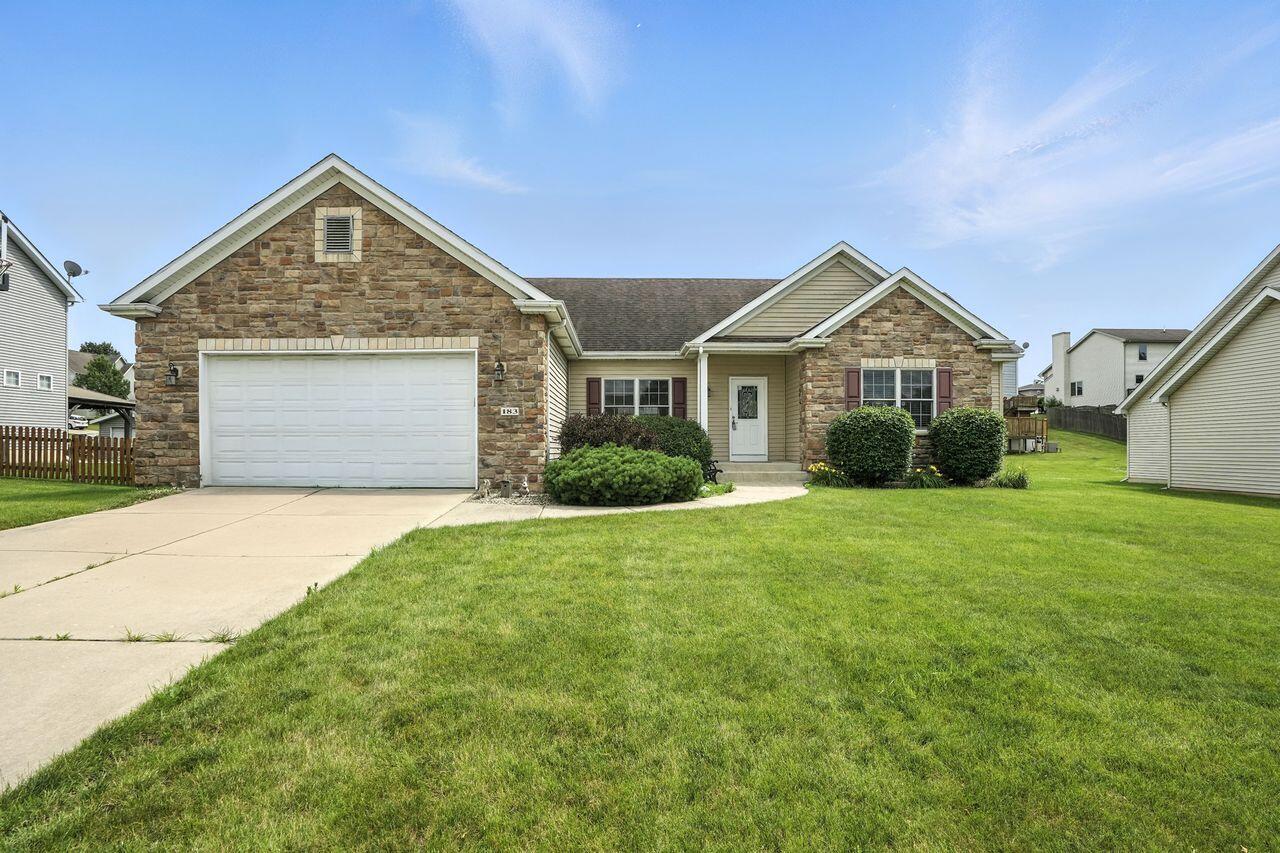 a front view of a house with a garden and garage