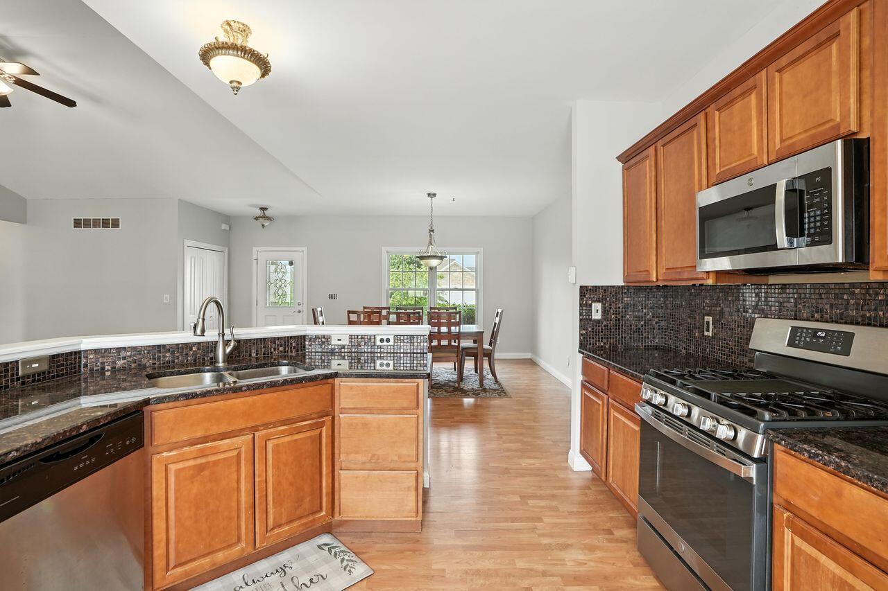 183 West 126th Place Crown Point, IN 46307 - Photo 7 of 25 a kitchen with granite countertop a sink a counter top space appliances and cabinets