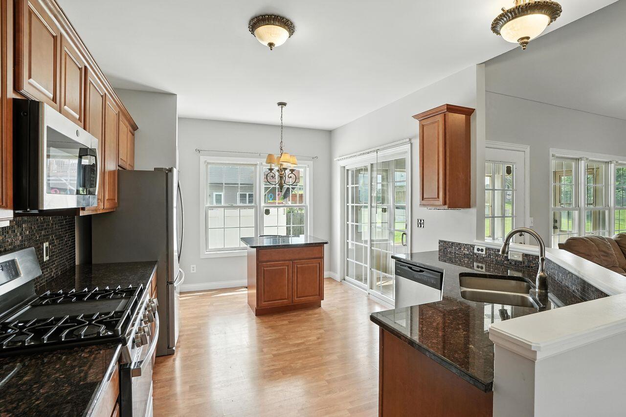 183 West 126th Place Crown Point, IN 46307 - Photo 9 of 25 a kitchen with stainless steel appliances granite countertop a sink stove and refrigerator