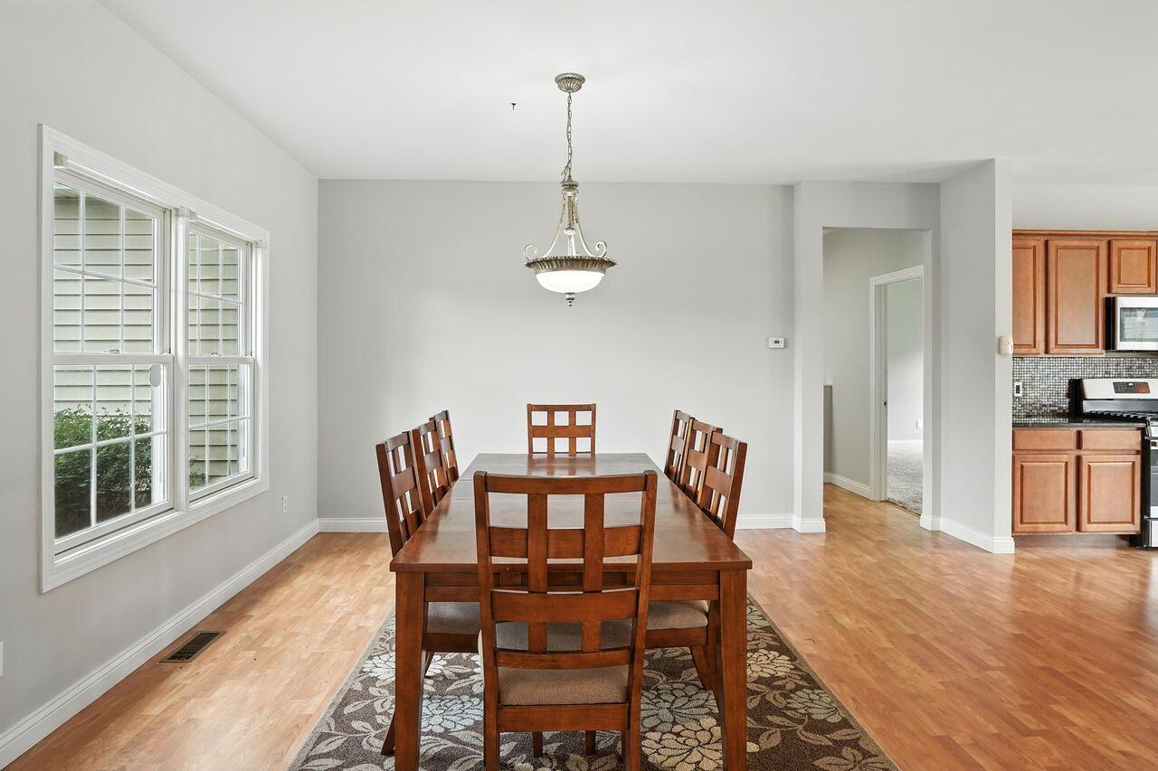 183 West 126th Place Crown Point, IN 46307 - Photo 10 of 25 a dining room with furniture a chandelier and wooden floor