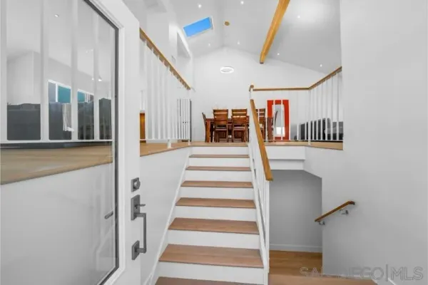 a view of staircase with lots of frames on wall and stairs