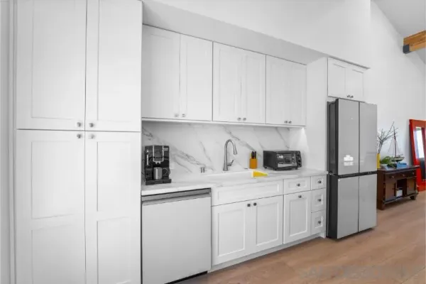 a kitchen with stainless steel appliances white cabinets and a refrigerator
