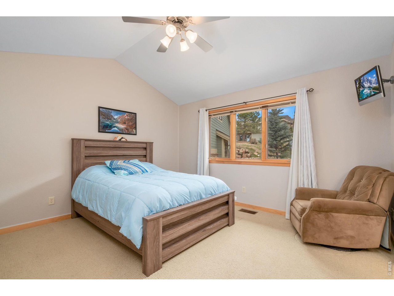 1761 Wildfire Road Estes Park, CO 80517 - Photo 19 of 45 a bedroom with a bed lamp and a window