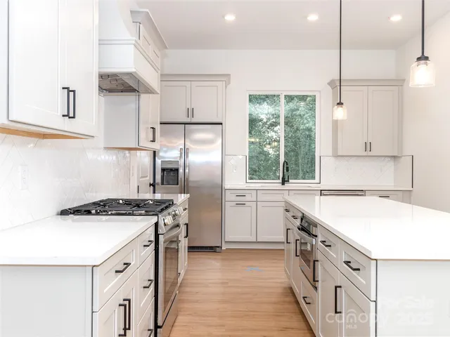 a kitchen with a stove a sink a refrigerator and a window