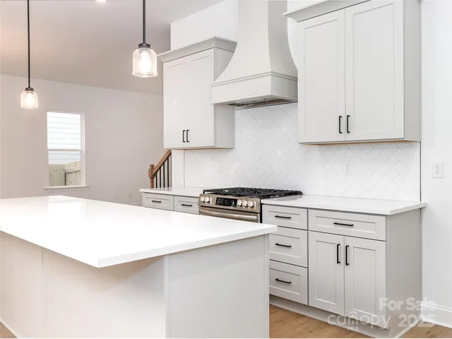 a kitchen with cabinets appliances a sink and a window