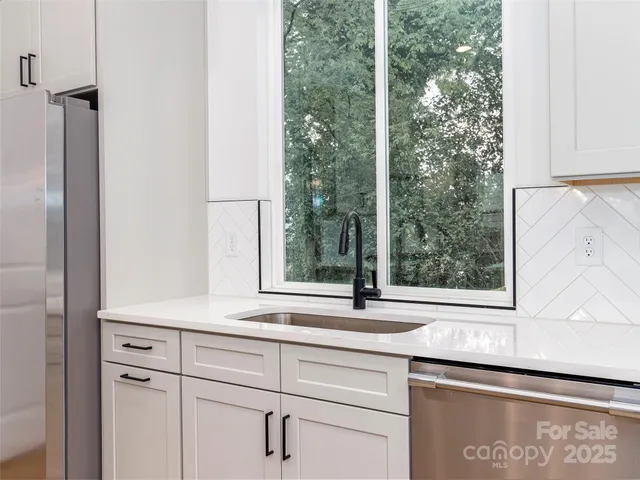 a bathroom with a sink and a large mirror next to a window