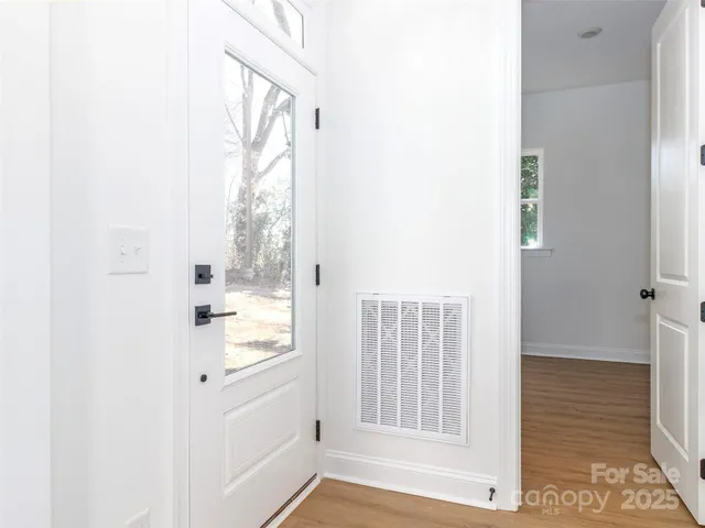 a view of a hallway with wooden floor and entryway
