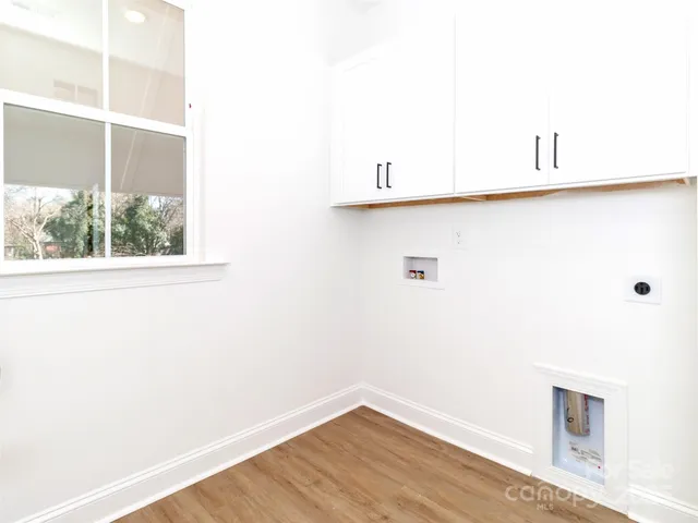 a view of a small space with wooden floor and a window