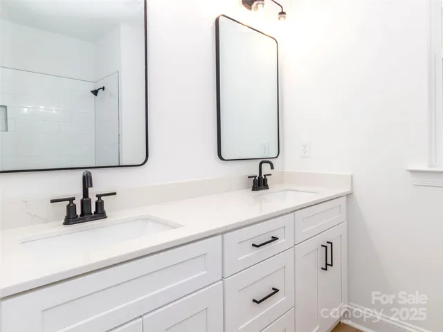 a bathroom with double vanity sink and a mirror