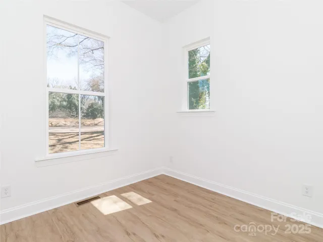 an empty room with wooden floor and a window